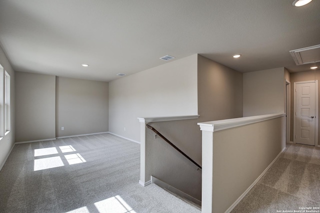 empty room featuring attic access, visible vents, carpet, and recessed lighting