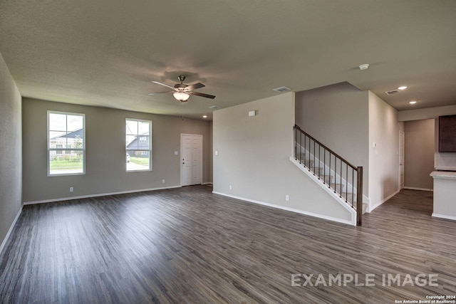 unfurnished living room featuring ceiling fan and dark hardwood / wood-style floors