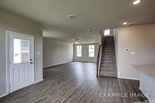 unfurnished living room featuring dark hardwood / wood-style floors and ceiling fan