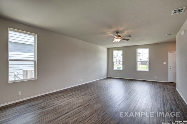 empty room with a textured ceiling, dark hardwood / wood-style flooring, and ceiling fan