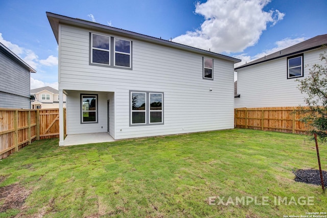 rear view of house featuring a yard and a patio