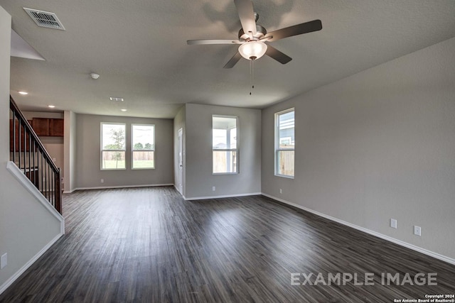 unfurnished room featuring a wealth of natural light, dark hardwood / wood-style flooring, and ceiling fan