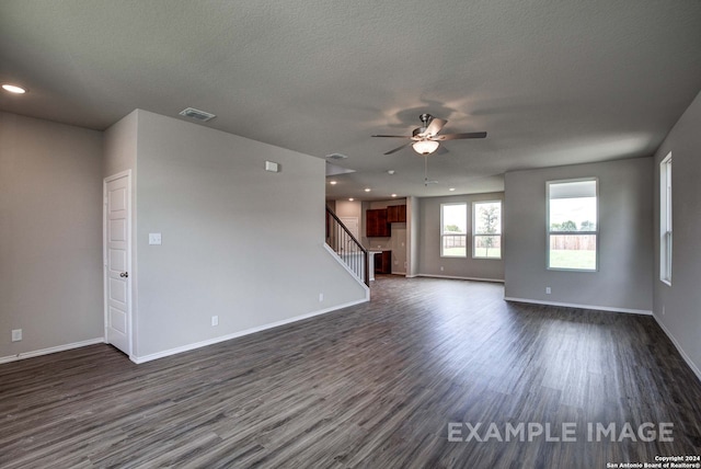 empty room featuring a textured ceiling, ceiling fan, and dark wood-type flooring