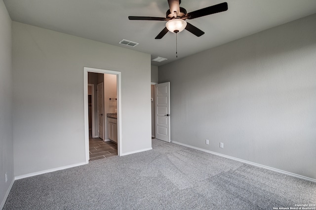 unfurnished bedroom with ensuite bathroom, ceiling fan, and carpet