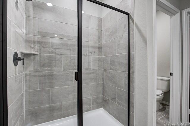 bathroom featuring toilet and an enclosed shower