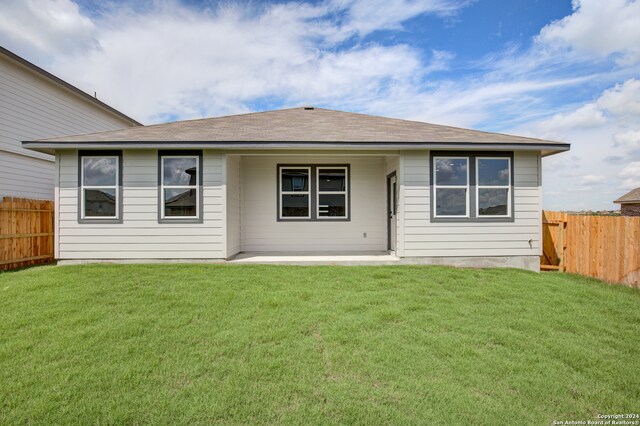 rear view of house with a yard and a patio area