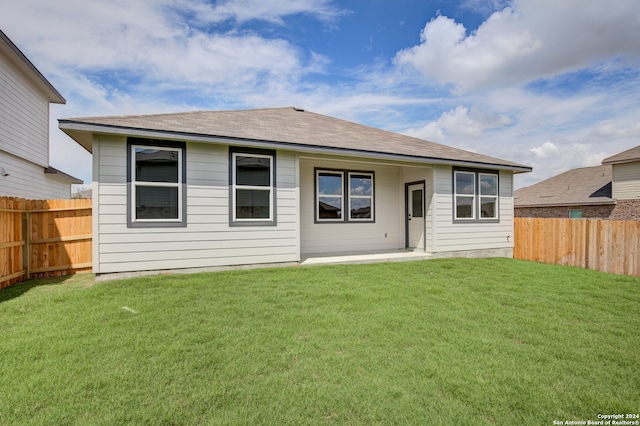 rear view of property featuring a yard