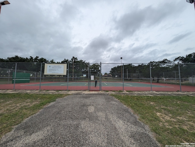 view of sport court with a lawn