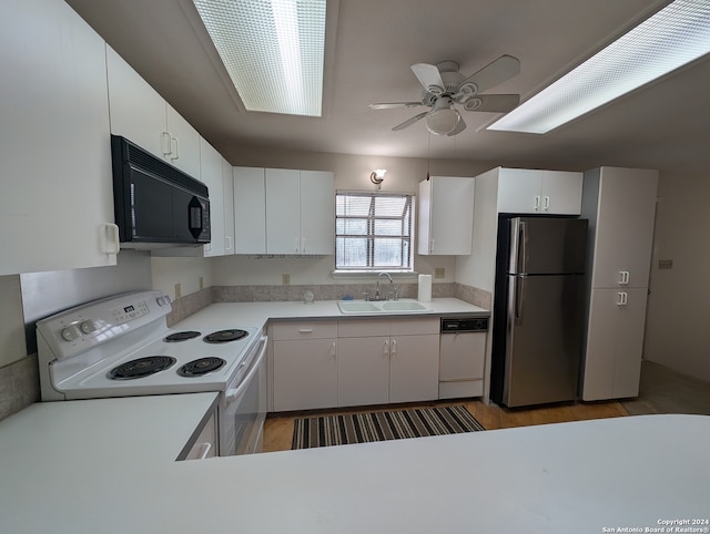 kitchen with ceiling fan, white appliances, sink, white cabinets, and hardwood / wood-style flooring