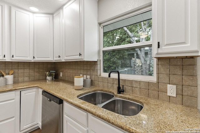 kitchen featuring white cabinetry, stainless steel dishwasher, tasteful backsplash, and sink