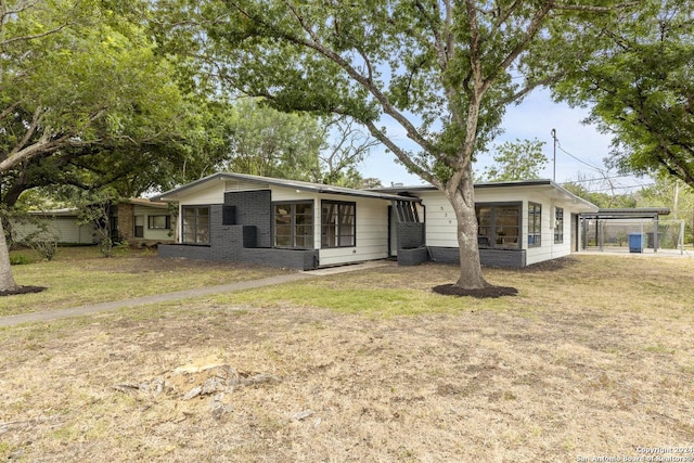 view of front of house with a carport and a front yard