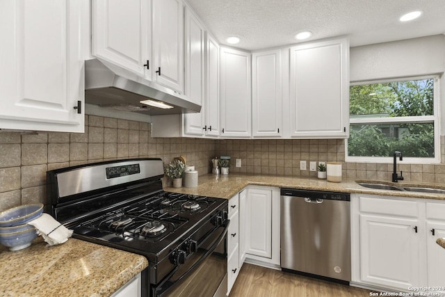 kitchen featuring white cabinetry, light hardwood / wood-style floors, and appliances with stainless steel finishes