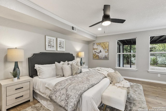 bedroom featuring hardwood / wood-style floors, ceiling fan, and crown molding