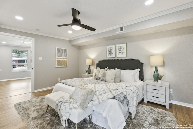 bedroom with hardwood / wood-style flooring, ceiling fan, and ornamental molding