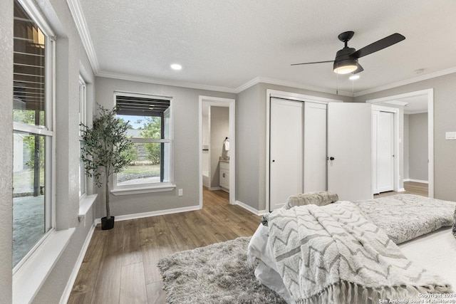 bedroom featuring hardwood / wood-style flooring, ceiling fan, ornamental molding, and a textured ceiling