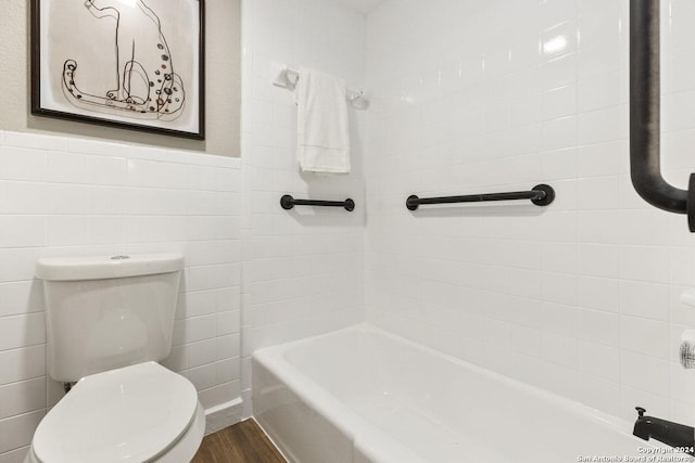 bathroom with a bathing tub, toilet, tile walls, and hardwood / wood-style flooring