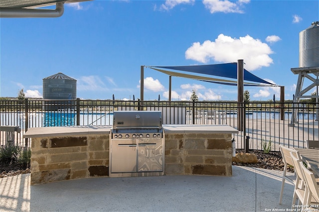 view of patio with area for grilling and a water view