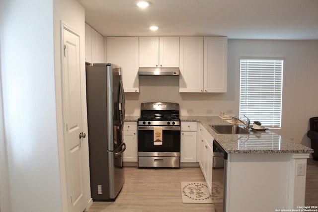 kitchen featuring white cabinets, sink, light hardwood / wood-style flooring, kitchen peninsula, and stainless steel appliances