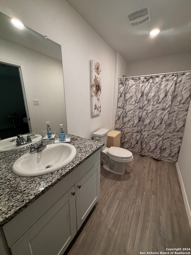 bathroom with hardwood / wood-style floors, vanity, and toilet