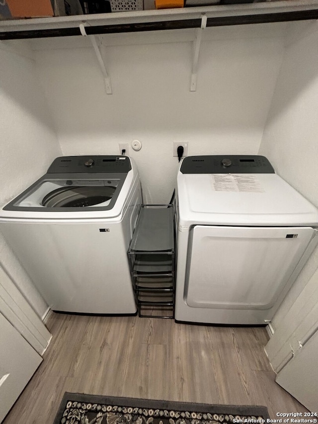 washroom featuring hardwood / wood-style flooring and washer and dryer