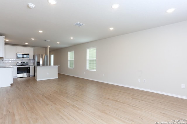 unfurnished living room featuring light hardwood / wood-style flooring and sink