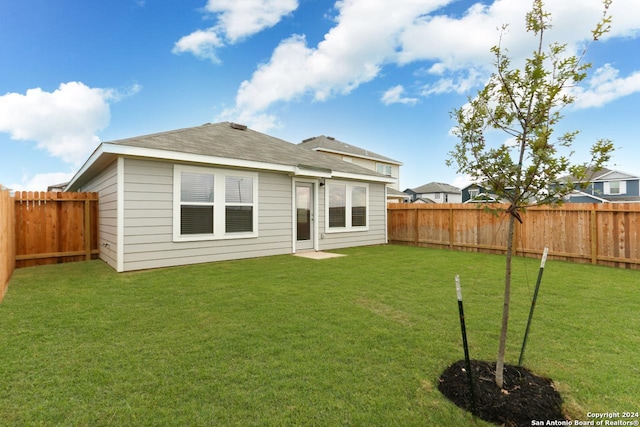 rear view of property featuring a lawn