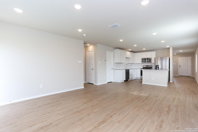 unfurnished living room featuring light hardwood / wood-style flooring and sink