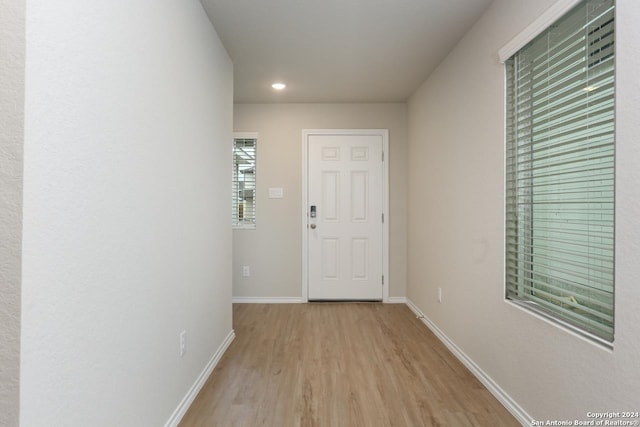 hallway with light hardwood / wood-style floors