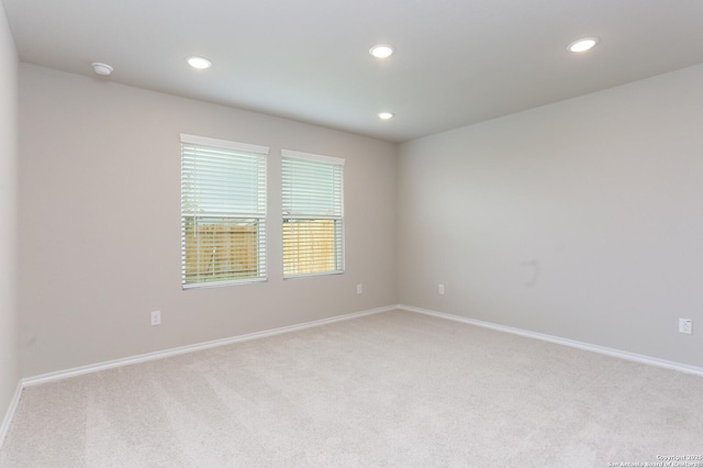 spare room featuring light carpet