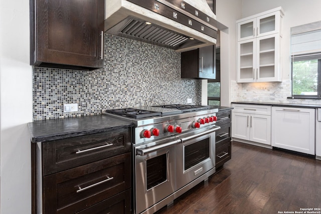 kitchen with white cabinets, double oven range, wall chimney exhaust hood, and decorative backsplash