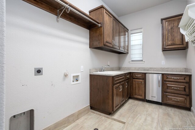 clothes washing area with sink, hookup for a washing machine, electric dryer hookup, and hookup for a gas dryer