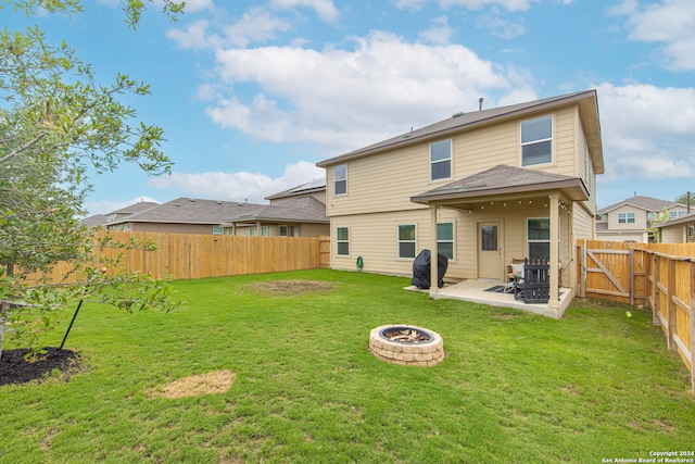 rear view of property with a patio, an outdoor fire pit, and a lawn