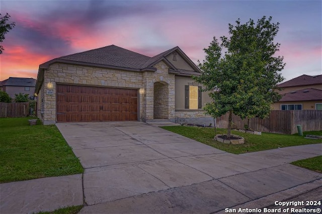 view of front of home featuring a garage and a lawn