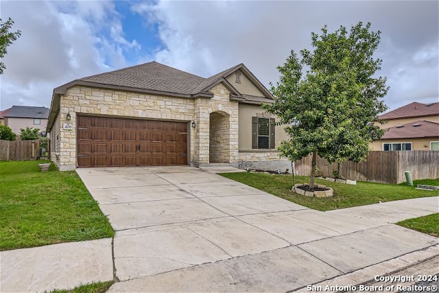 view of front of property featuring a front yard and a garage