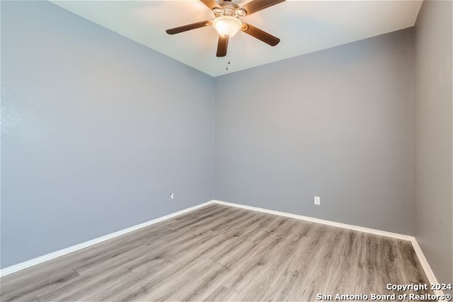 empty room with ceiling fan and light hardwood / wood-style flooring