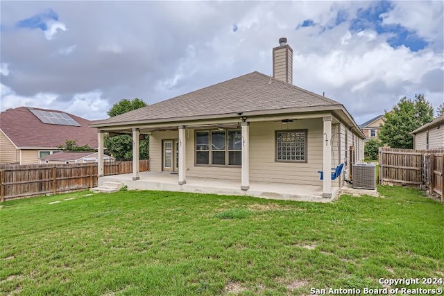 rear view of house featuring central AC unit, a patio area, and a yard