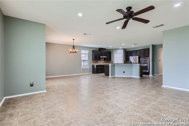 unfurnished living room featuring ceiling fan with notable chandelier