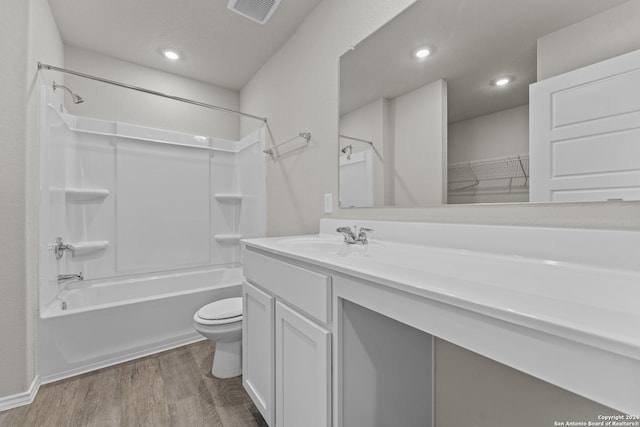 full bathroom featuring washtub / shower combination, vanity, hardwood / wood-style flooring, and toilet