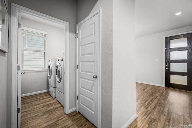 clothes washing area with independent washer and dryer, a wealth of natural light, and dark wood-type flooring