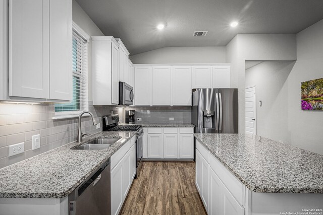 kitchen with sink, white cabinets, a kitchen island, and appliances with stainless steel finishes