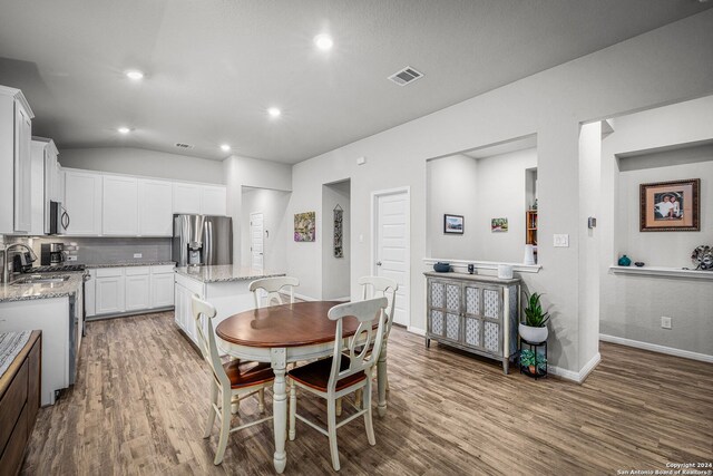 dining room with wood-type flooring and lofted ceiling