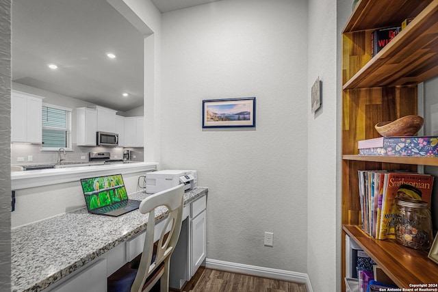 kitchen featuring light stone counters, stainless steel appliances, dark wood-type flooring, sink, and white cabinetry