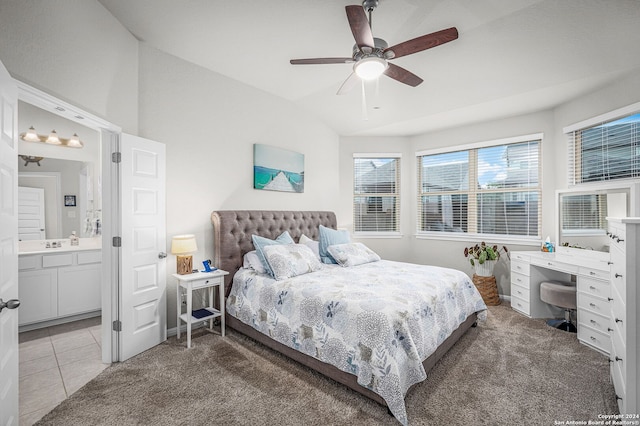 bedroom featuring ceiling fan, carpet floors, ensuite bathroom, and vaulted ceiling