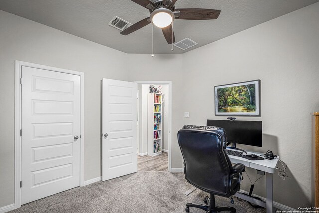 carpeted office with ceiling fan and a textured ceiling