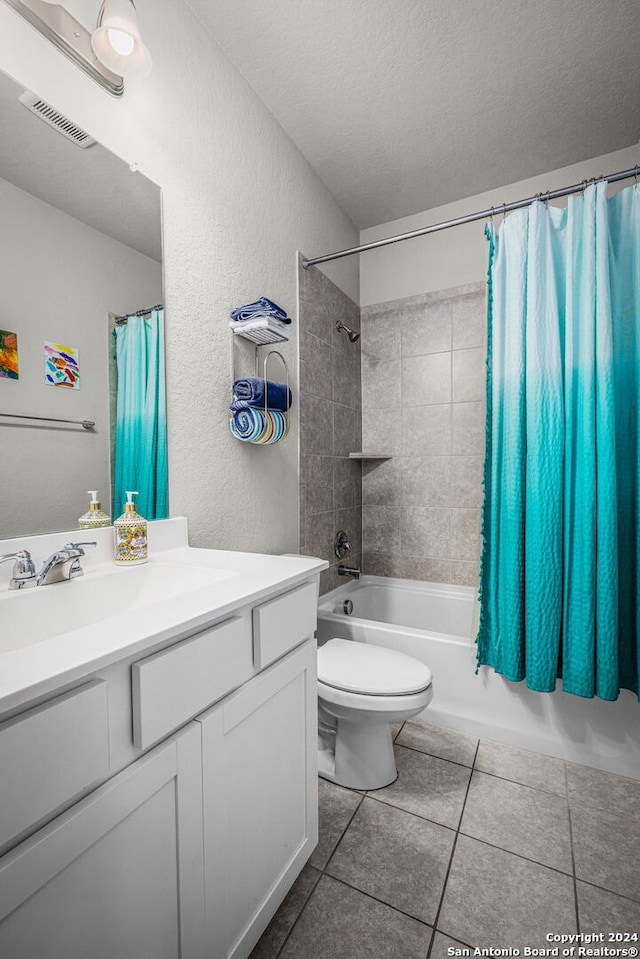 full bathroom with tile patterned floors, vanity, a textured ceiling, shower / tub combo with curtain, and toilet