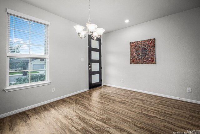 foyer entrance featuring hardwood / wood-style flooring and a notable chandelier