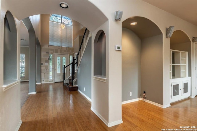 foyer with light hardwood / wood-style flooring and a towering ceiling