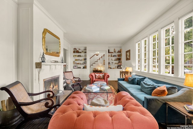 living room with crown molding and built in shelves