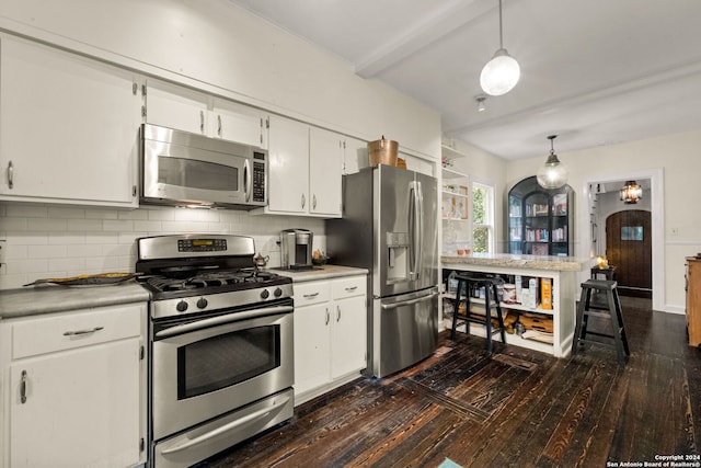 kitchen with dark hardwood / wood-style floors, tasteful backsplash, stainless steel appliances, hanging light fixtures, and white cabinetry