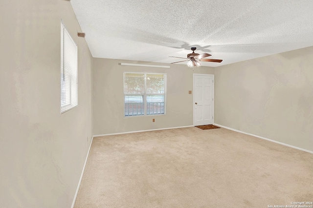 carpeted empty room featuring a textured ceiling and ceiling fan